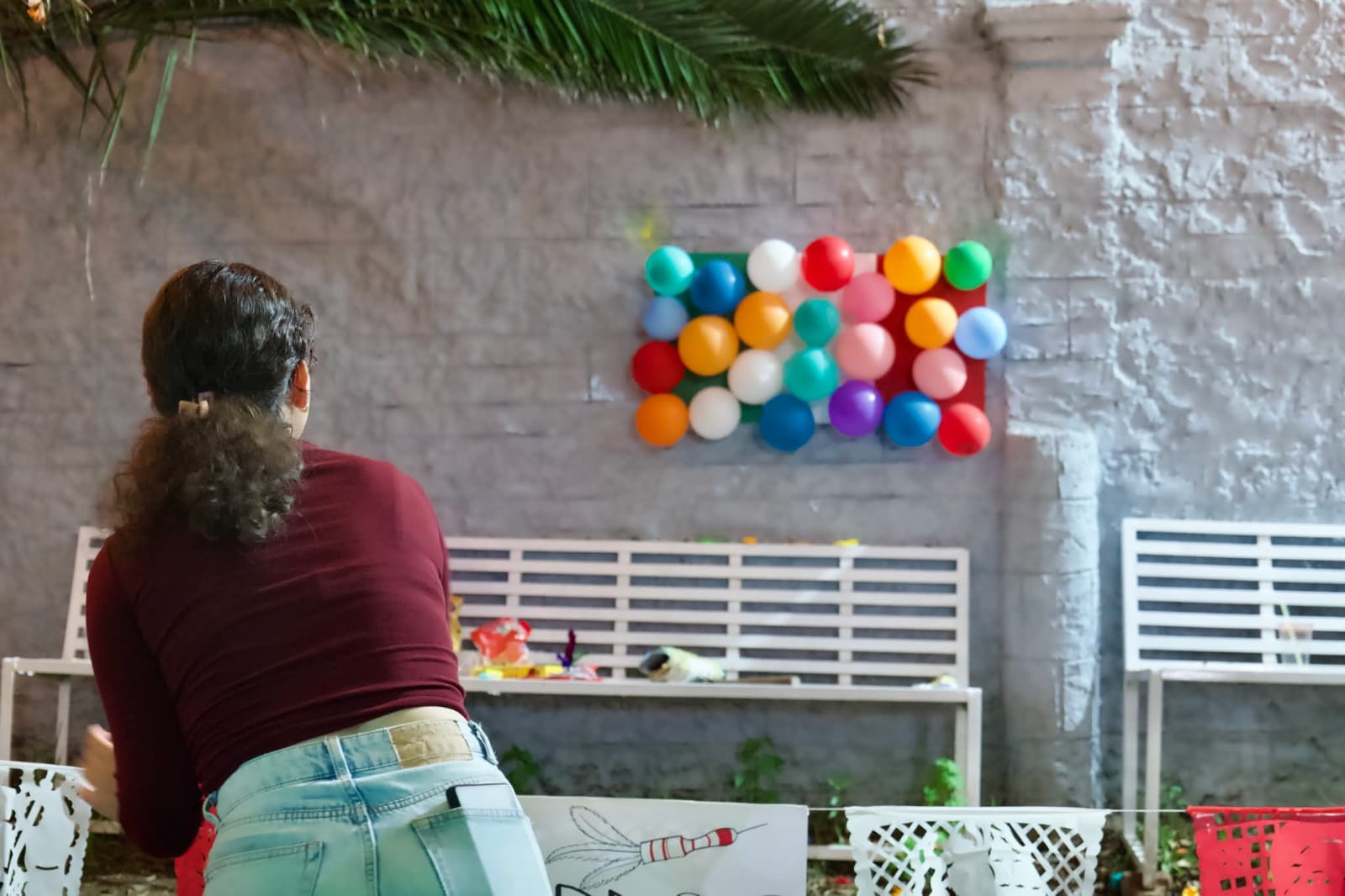 Persona jugando a los dardos con globos